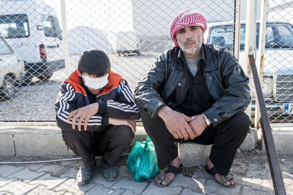 Mohamed Rahmo and his blinded son, Mustafa, on their way back to Syria. Photo: © Elio Germani